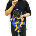 55cm Bali multicoloured dreamcatcher with rainbow feathers, woven web and decorative beads, on a white background