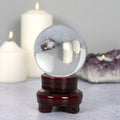 Clear 8cm crystal ball displayed on a wooden stand, designed for decorative display and crystal collections.