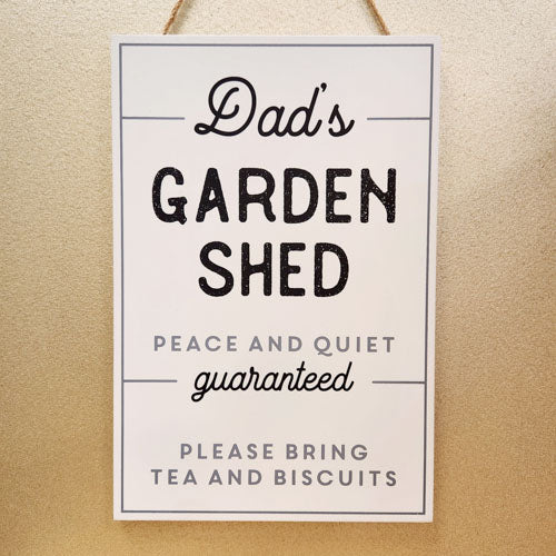 Rustic wooden hanging sign reading “Dad’s Garden Shed” with decorative design and rope hanger.