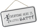 White rectangular metal hanging sign with the phrase "Everyone Here Is A Little Batty" and a dancing skeleton illustration on the left.