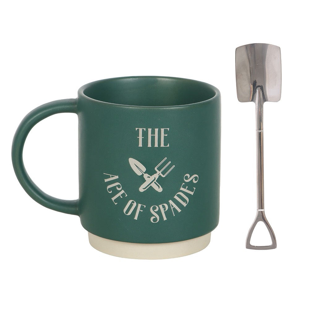 Dark green ceramic mug with "The Ace of Spades" text and crossed garden tool illustration, shown alongside a stainless steel spade-shaped teaspoon
