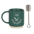 Dark green ceramic mug with "The Ace of Spades" text and crossed garden tool illustration, shown alongside a stainless steel spade-shaped teaspoon