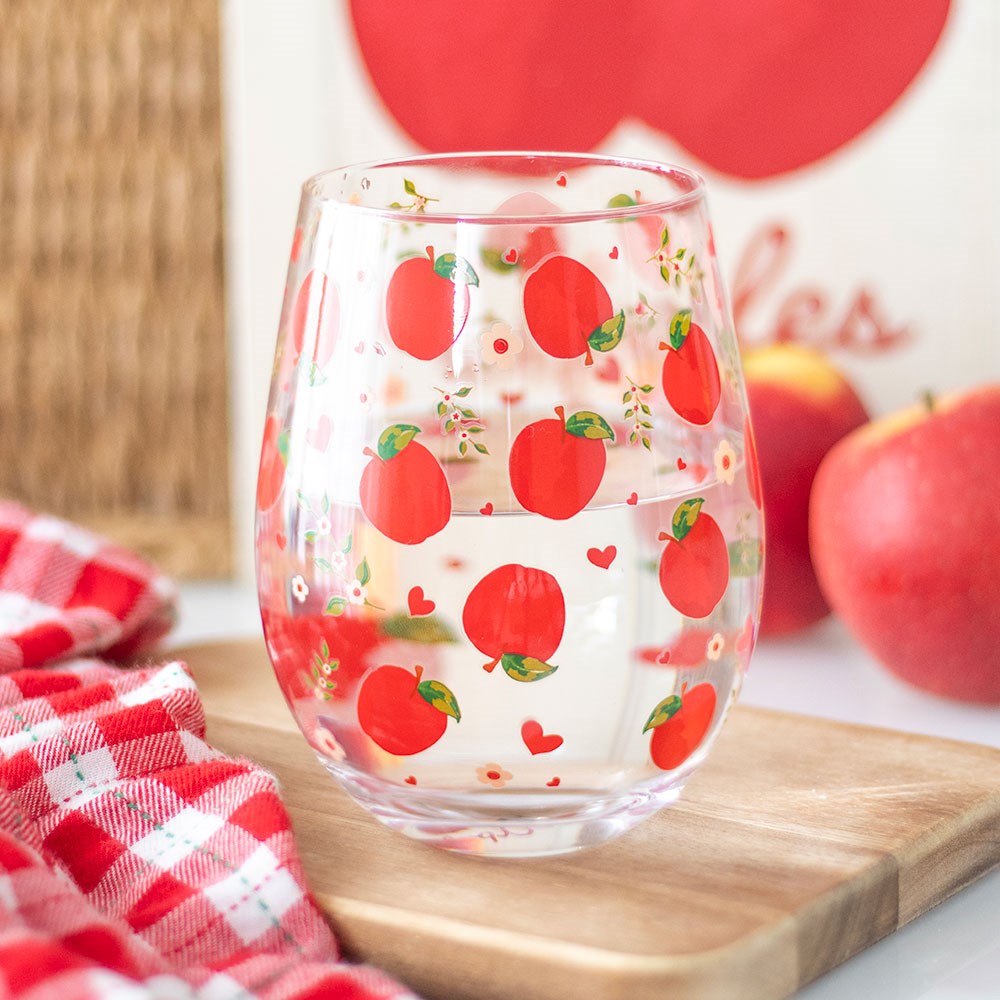 Stemless wine glass featuring decorative apple print pattern with colourful fruit-themed design.