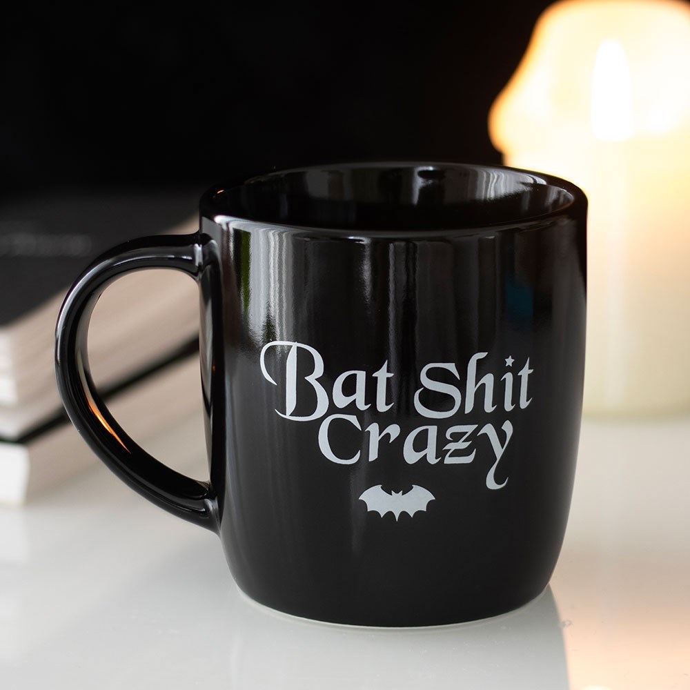 Black ceramic mug featuring “Bat Shit Crazy” text with gothic bat-themed design and classic mug shape.