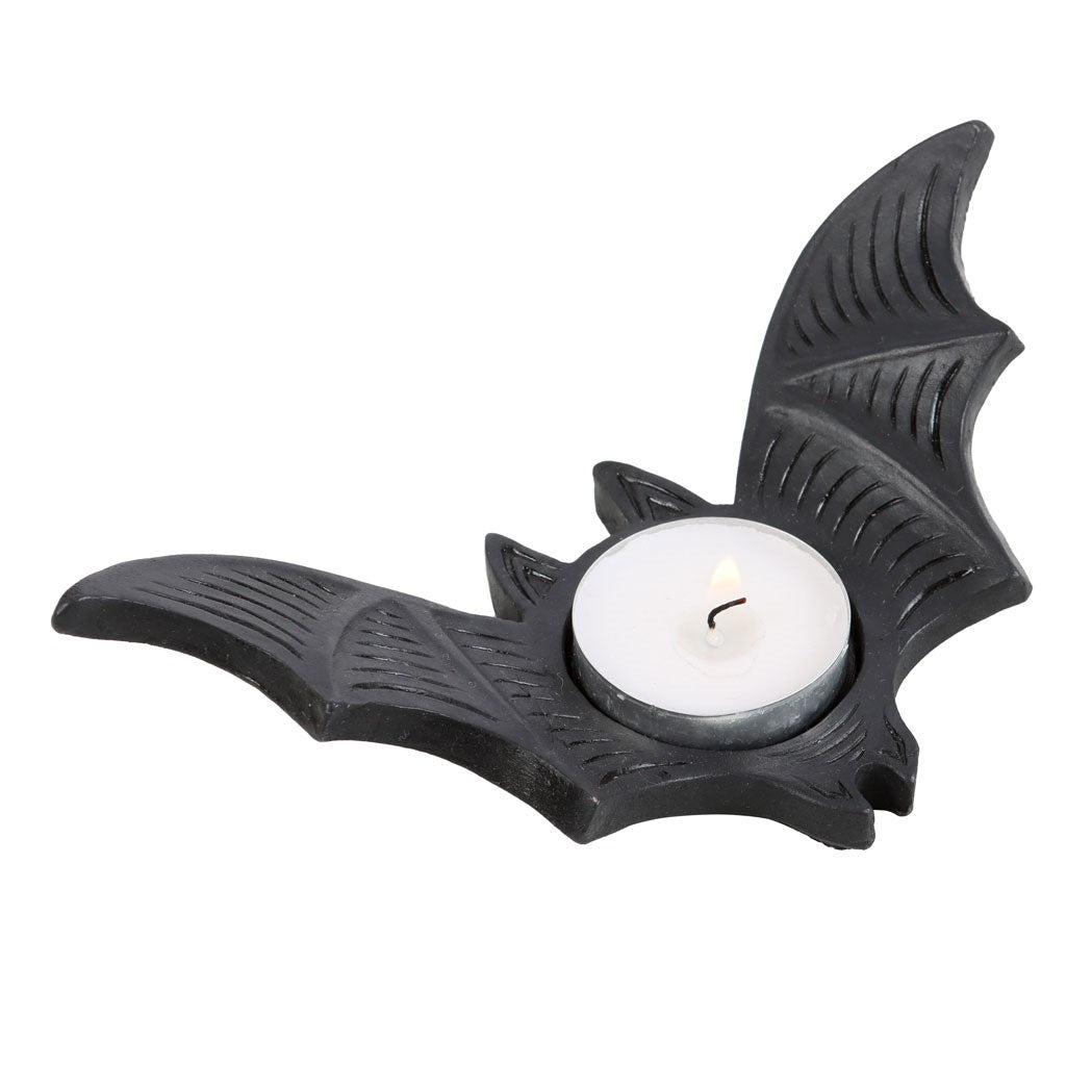 Black bat-shaped tealight candle holder with detailed wing texture, holding a white tealight candle on a white background