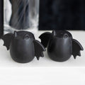 Black bat wing shaped salt and pepper shakers with gothic decorative design for kitchen or dining table use.
