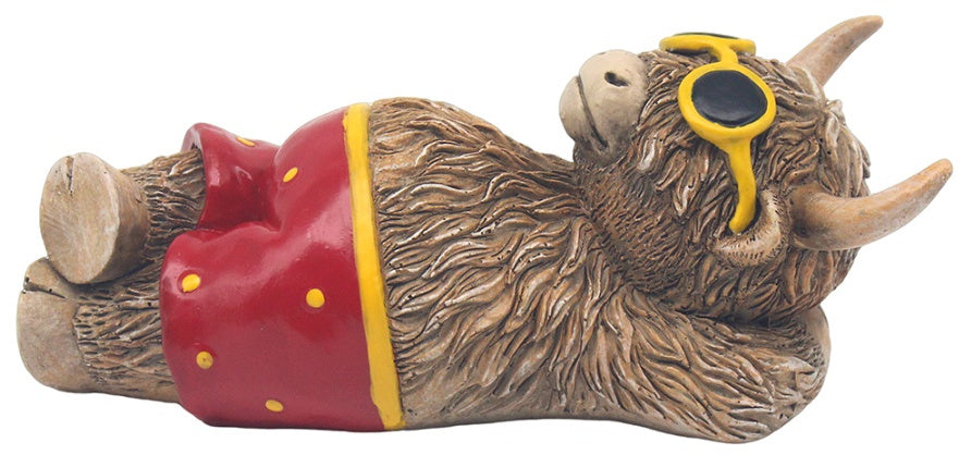 Highland cow ornament wearing colourful swim shorts with playful beach-themed decorative design.