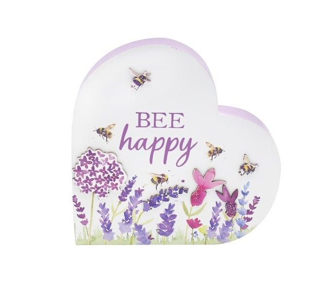 Heart-shaped wooden block sign featuring the phrase “Bee Happy” with decorative flowers and bee illustrations in purple and natural wood tones.