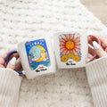 Matching mug set featuring sun and moon celestial designs with decorative cosmic-themed artwork.