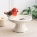 Ceramic trinket dish featuring a robin perched on a bird bath, ideal for holding small jewellery and keepsakes with a decorative, nature-inspired design.