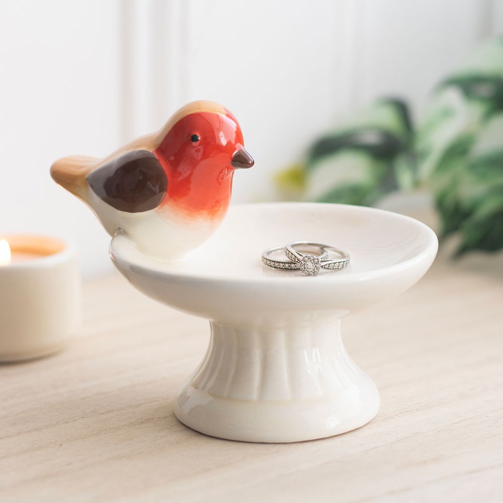 Ceramic trinket dish featuring a robin perched on a bird bath, ideal for holding small jewellery and keepsakes with a decorative, nature-inspired design.