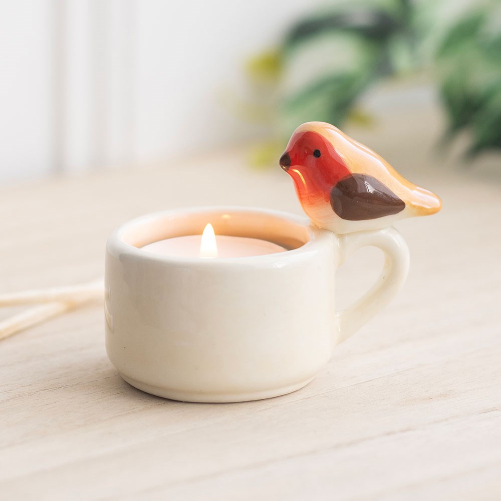Ceramic tealight candle holder featuring a robin design, holding a small candle to create a warm, soft glow and decorative nature-inspired ambience.