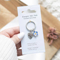 Metal keyring featuring a forget-me-not flower charm with blue enamel detailing and attached keyring loop.