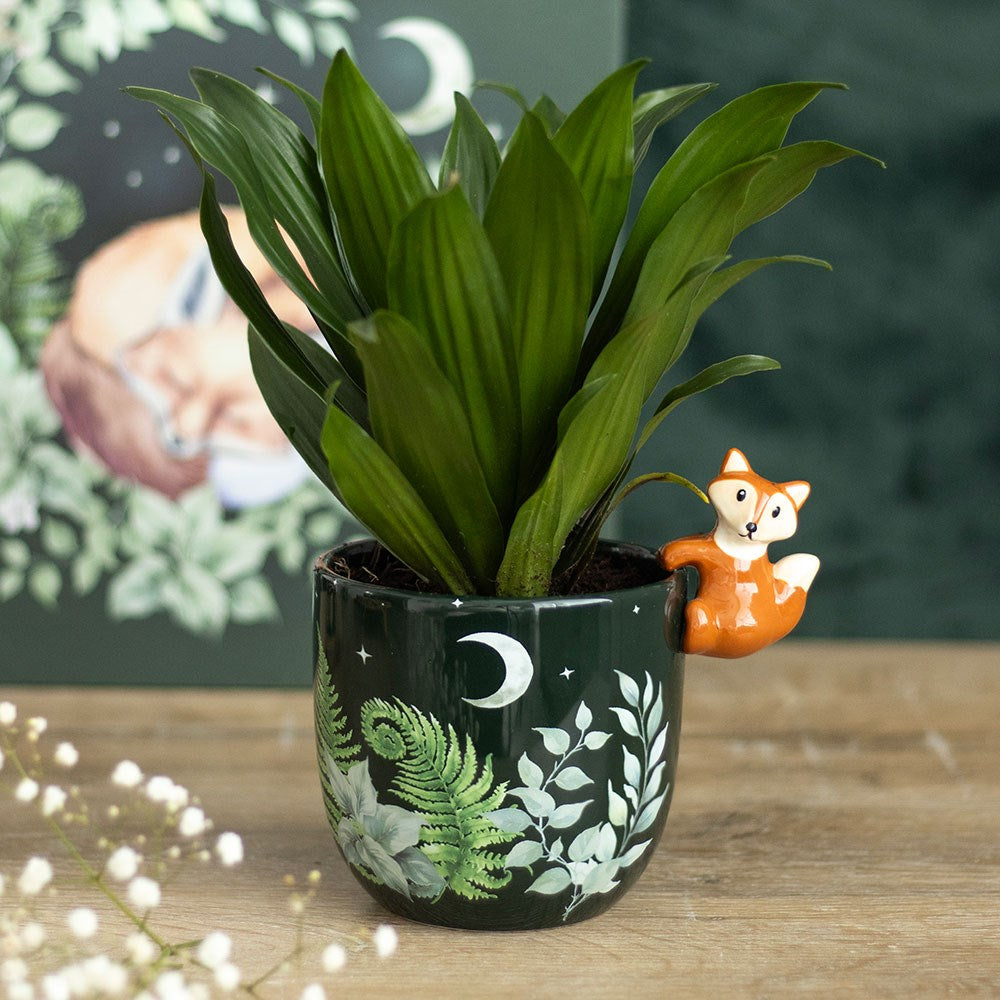 Green forest themed plant pot with decorative fox pot hanger for indoor plant display.