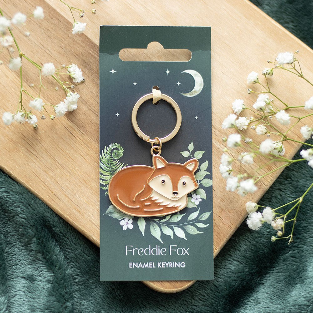 Fox-shaped metal and enamel keyring named Freddie the Fox with detailed woodland-inspired design and attached keyring loop.