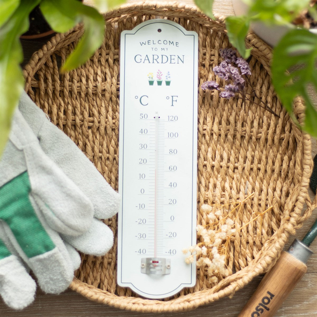 Pale green wooden wall thermometer with "Welcome To My Garden" text, three flower pot illustrations, and dual Celsius and Fahrenheit temperature scale