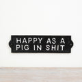 Cast iron sign reading “Happy As A Pig In Sh1t” with rustic vintage-style decorative finish.