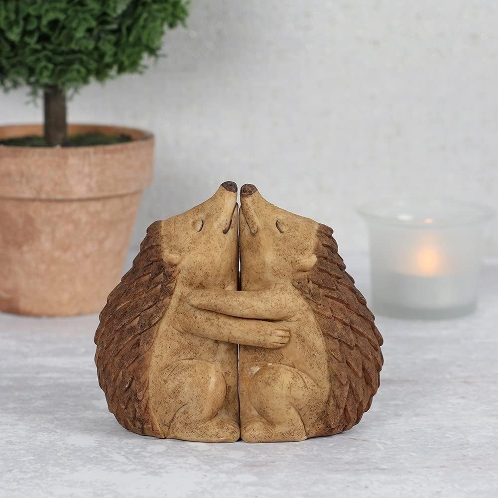 Decorative figurine featuring two hedgehogs cuddled closely together, with textured detailing and a rustic woodland-inspired finish symbolising love and companionship.