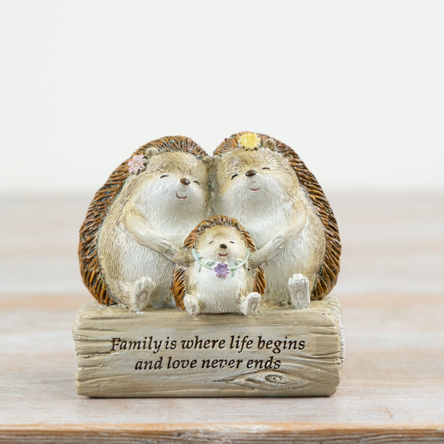 Decorative hedgehog family ornament featuring two adult hedgehogs and a baby hedgehog with the sentiment “Family is where life begins and love never ends”.