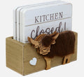 Set of 4 white wooden coasters each with a different slogan, stored in a wooden Highland cow coaster holder, on a white background

