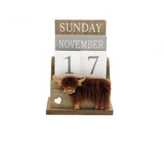 Wooden perpetual block calendar with Highland cow figurine on the base, displaying Sunday November 17, on a white background


