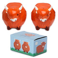 Set of two orange Highland Cow ceramic salt and pepper pots featuring detailed cow faces with white horns.