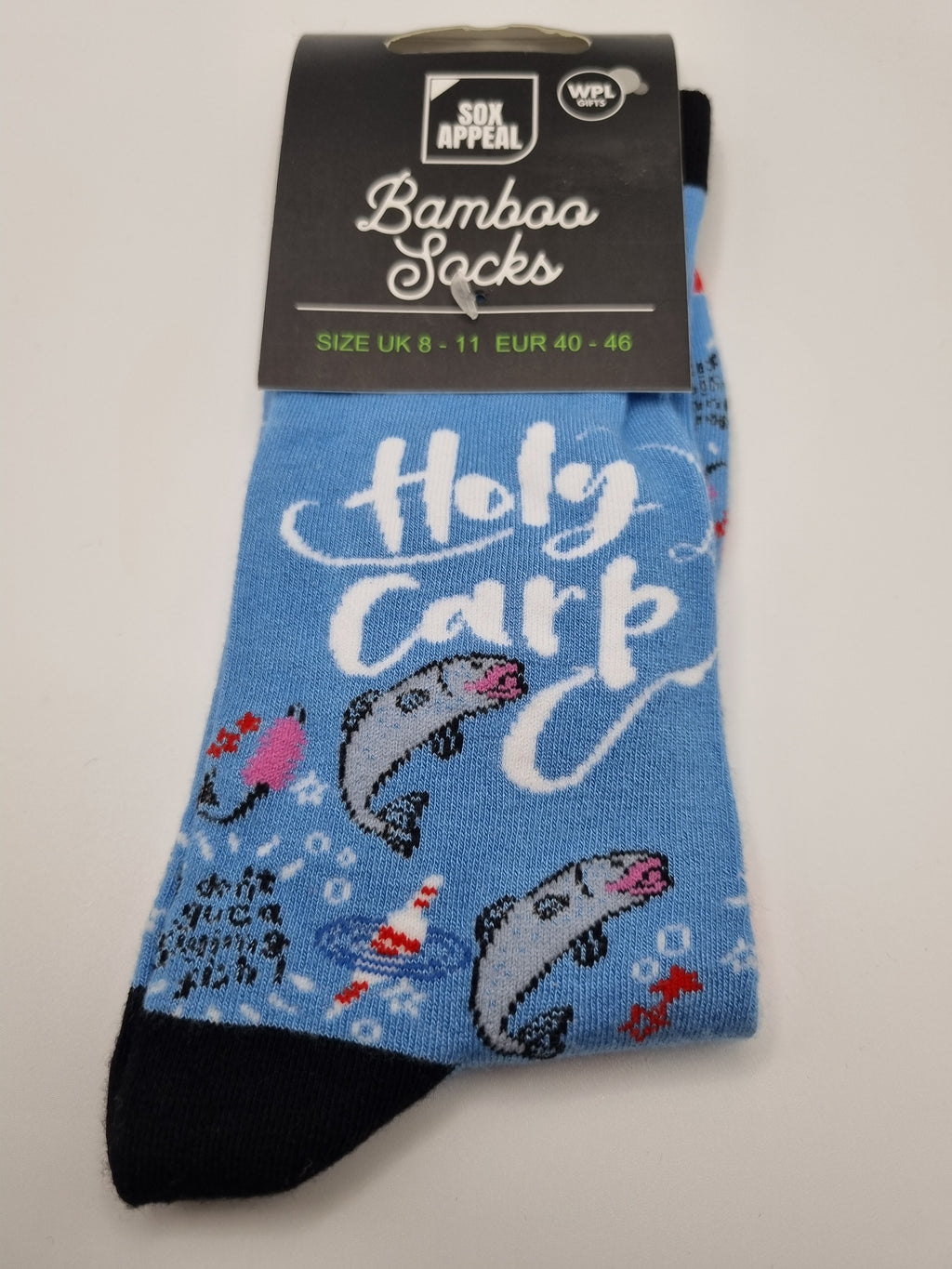 Blue Holy Carp novelty men's bamboo socks with leaping carp fish illustration and white script text, dark navy cuffs and toes, UK size 8–11, shown in packaging