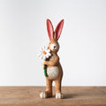 Jasper rabbit holding daisy figurine, a sweet floral-themed ornament