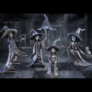 Group of four Nemesis Now Little Souls gothic witch figurines in dark robes and oversized hats, each with a unique companion, displayed in a dramatic stone setting
