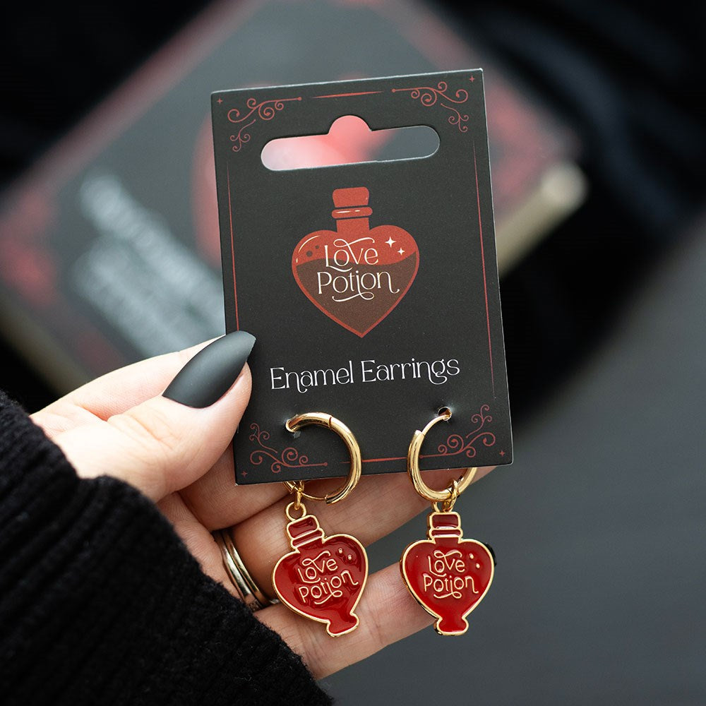 Metal and enamel earrings shaped like potion bottles, featuring a colourful “Love Potion” inspired design with hanging hooks.
