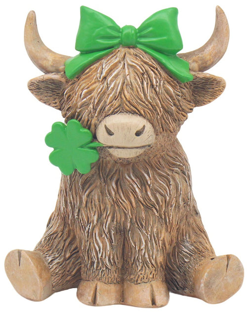 Highland cow ornament holding a clover and featuring “Lucky Girl” theme with decorative countryside-inspired design.
