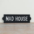 Wall mounted cast iron sign reading “Mad House” with rustic vintage-style humorous decorative design.