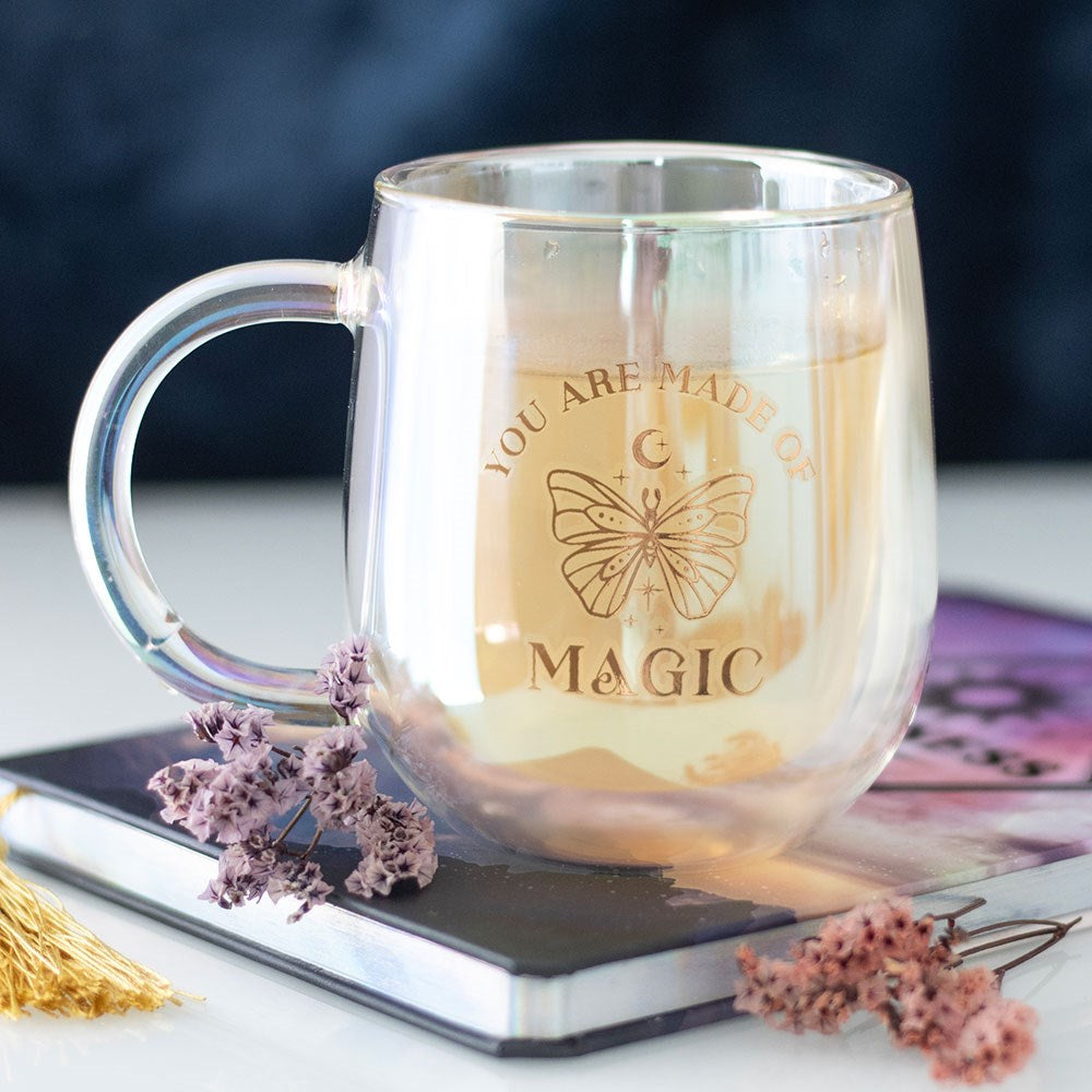 Iridescent double walled glass mug engraved with You Are Made of Magic butterfly and moon design, styled with dried flowers and a journal