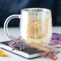 Iridescent double walled glass mug engraved with You Are Made of Magic butterfly and moon design, styled with dried flowers and a journal