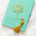 Gold-coloured metal bookmark shaped like a lotus flower with decorative tassel, ideal for marking pages with a touch of elegance and symbolism.