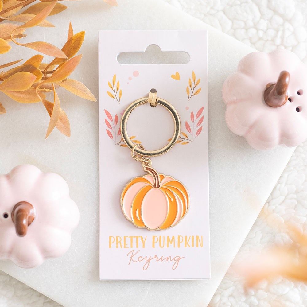 Alloy and enamel pumpkin keyring featuring a pastel orange pumpkin charm on a gold-tone key ring, displayed on branded backing card.