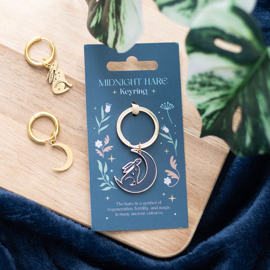 Metal and enamel keyring featuring a gazing hare design with midnight-inspired detailing and attached keyring loop.