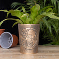 Bronze-effect terracotta planter featuring an embossed moon gazing hare design surrounded by foliage and celestial details.