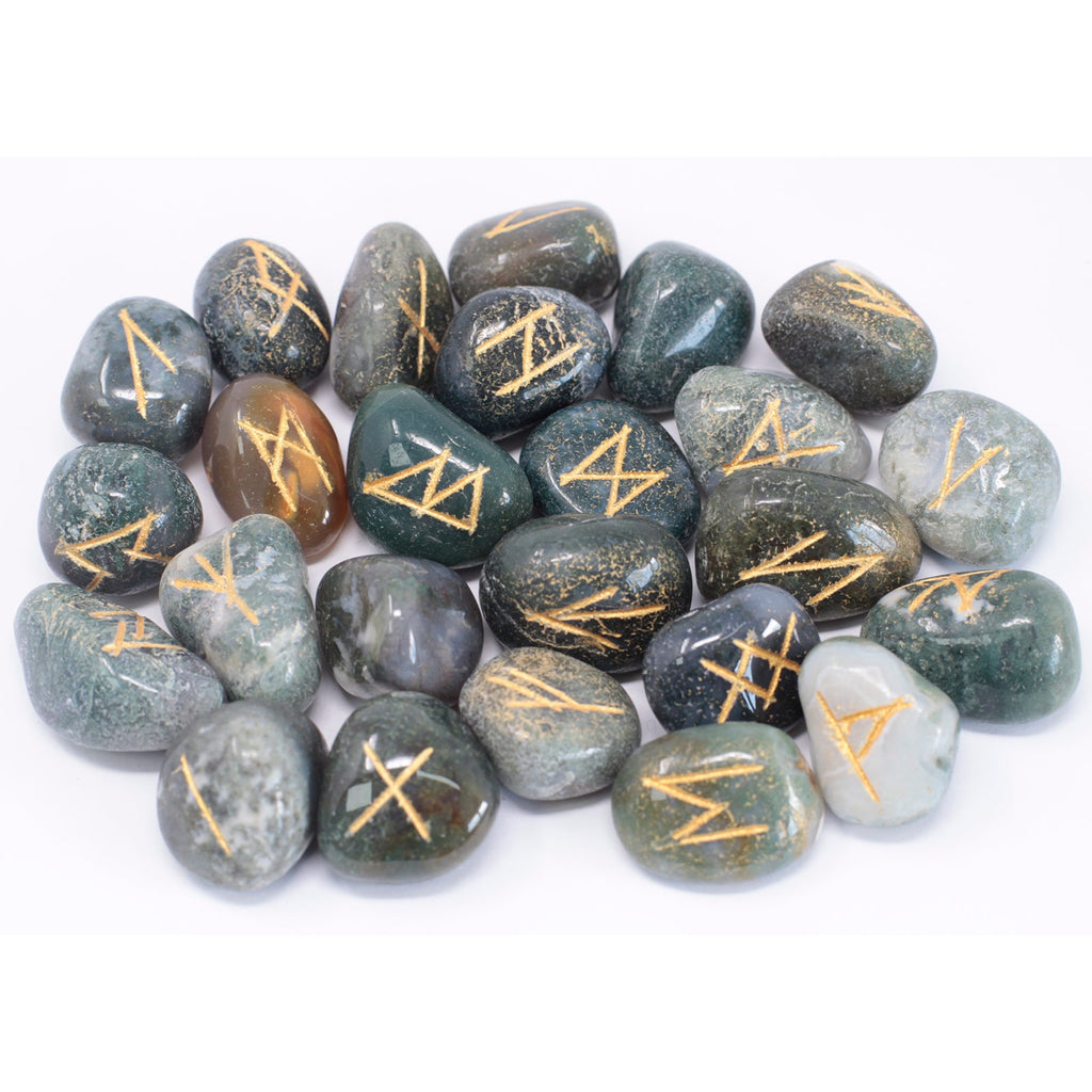 Moss agate rune stone set featuring engraved symbols on natural green gemstone pieces used for divination and spiritual practices.