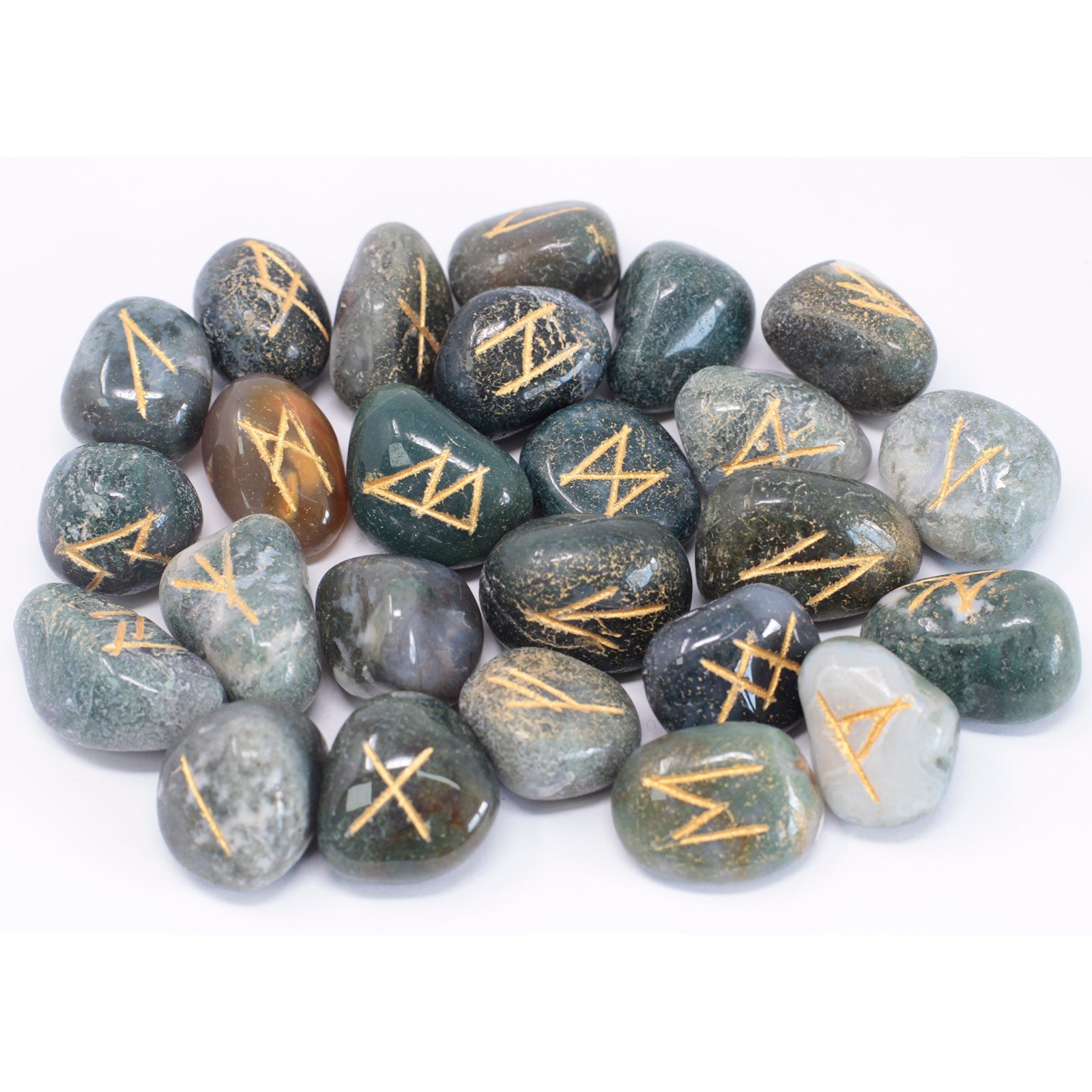 Moss agate rune stone set featuring engraved symbols on natural green gemstone pieces used for divination and spiritual practices.