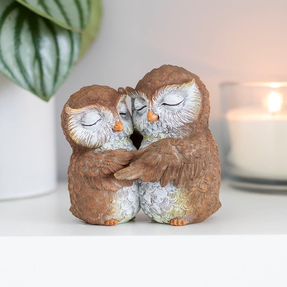 Decorative figurine featuring two owls nestled together in an affectionate embrace, with detailed feather texture and a rustic woodland-inspired finish.