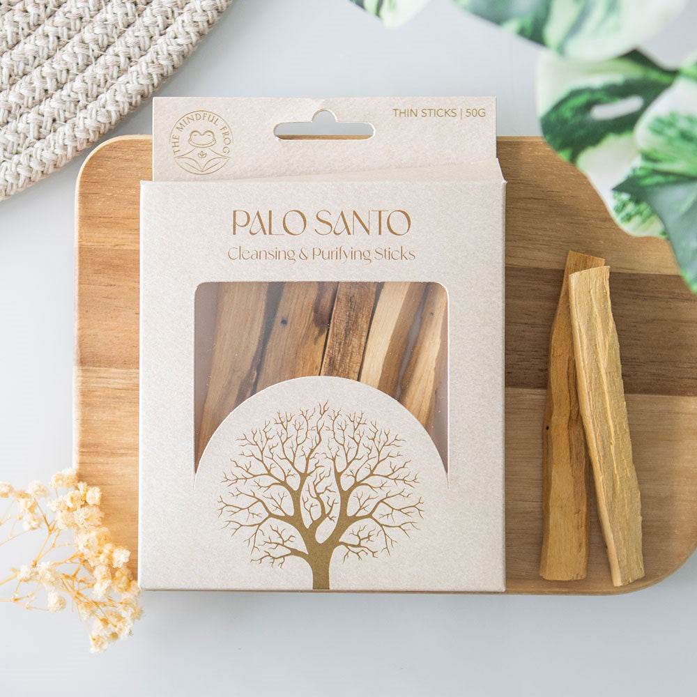 Palo Santo cleansing and purifying thin sticks 50g in a cream gift box with tree design and clear window, displayed on a wooden board with dried flowers