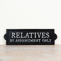Cast iron sign featuring “Relatives By Appointment Only” text in rustic vintage-style design.