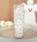 Tall glass tube scented candle with gold stars, feathers and hearts design, tied with twine and a Remember An Angel gift tag, styled with white angel figurines in the background