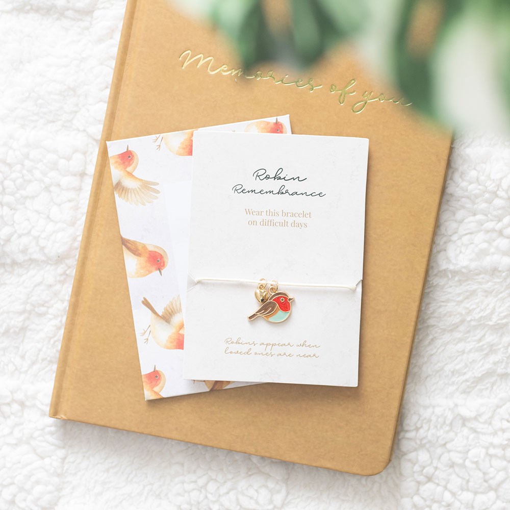 Delicate string charm bracelet featuring a robin motif with a sentiment card, designed as a meaningful remembrance gift symbolising love and memory.