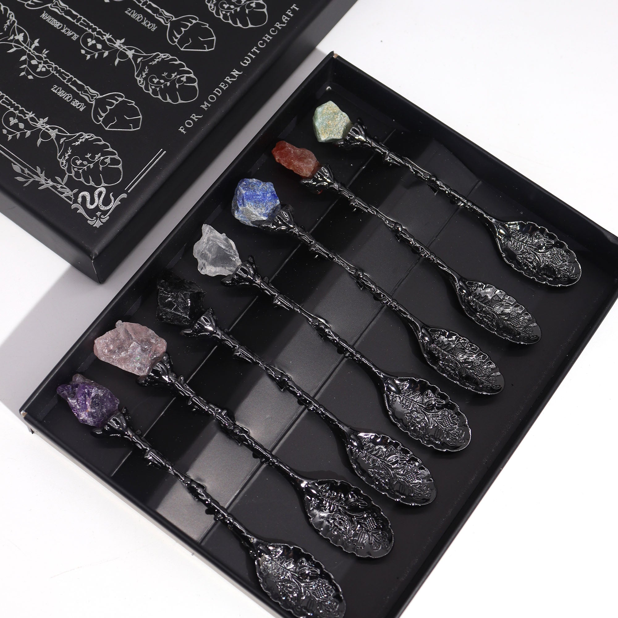 Set of decorative spoons with embedded crystals in a black box