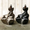 Ceramic backflow incense cone burner with waterfall design and cascading smoke effect when in use.