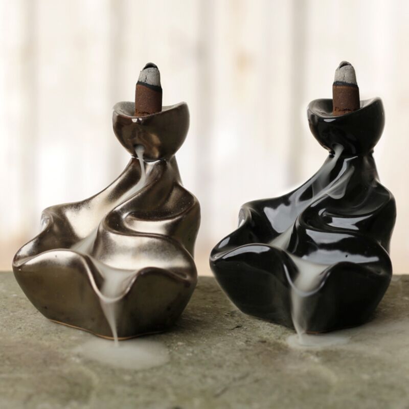 Ceramic backflow incense cone burner with waterfall design and cascading smoke effect when in use.