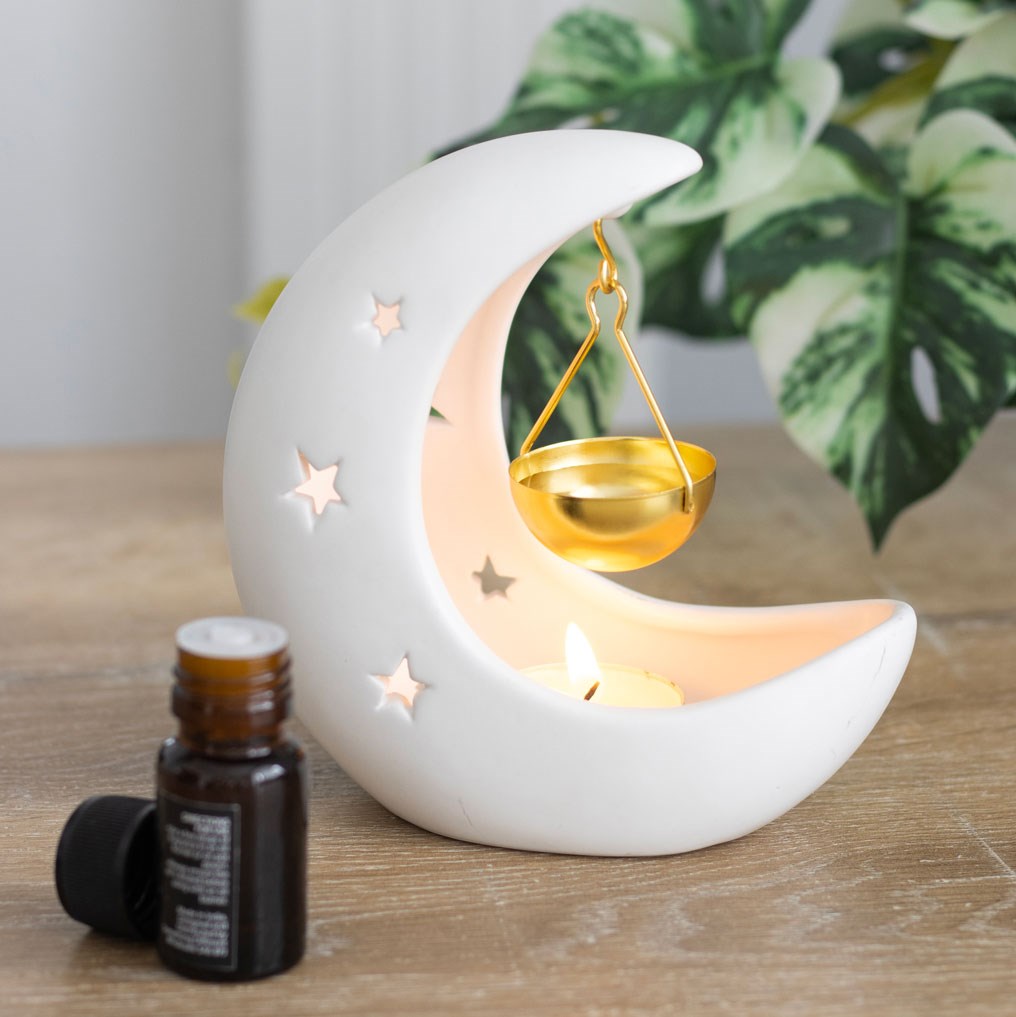 White ceramic crescent moon oil burner and wax melter with celestial-inspired decorative design.